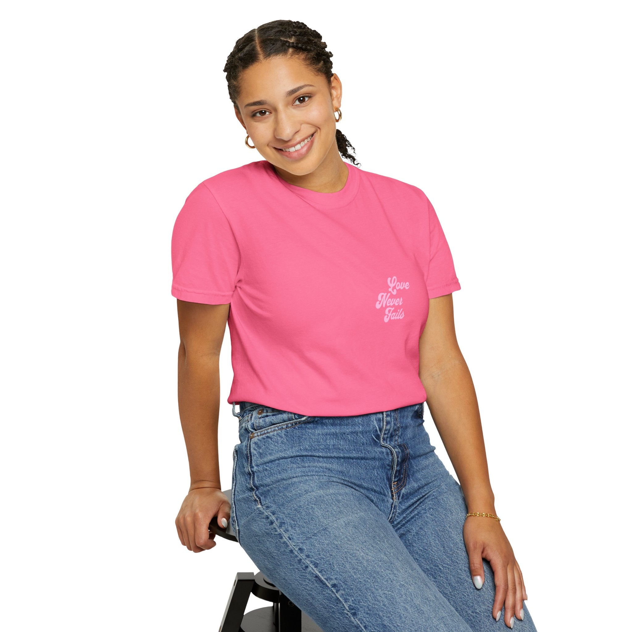 Person wearing a pink t-shirt with a logo and blue jeans on a white background