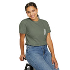 Woman wearing a green t-shirt and blue jeans sitting on a stool against a white background