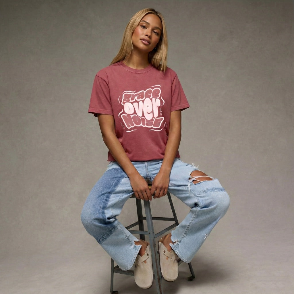 Woman wearing a maroon Grace Over Noise unisex t-shirt with white bubbly streetwear typography by Way Is Made 4