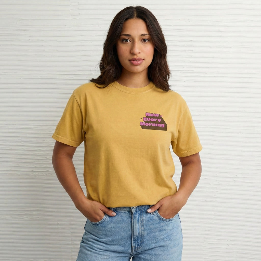 Close up of New Every Morning scripture design on mustard yellow cotton t-shirt