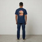 Back view of navy Way Is Made t-shirt with Enough Light For Today sunset graphic in a vertical arch.