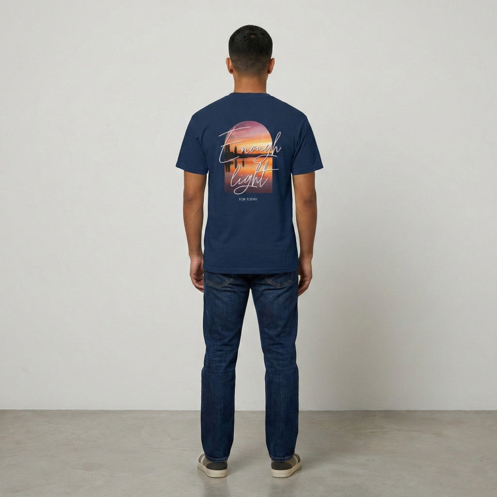 Back view of navy Way Is Made t-shirt with Enough Light For Today sunset graphic in a vertical arch.
