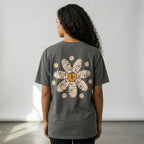 Person wearing a dark gray t-shirt with a floral design on the back against a plain background