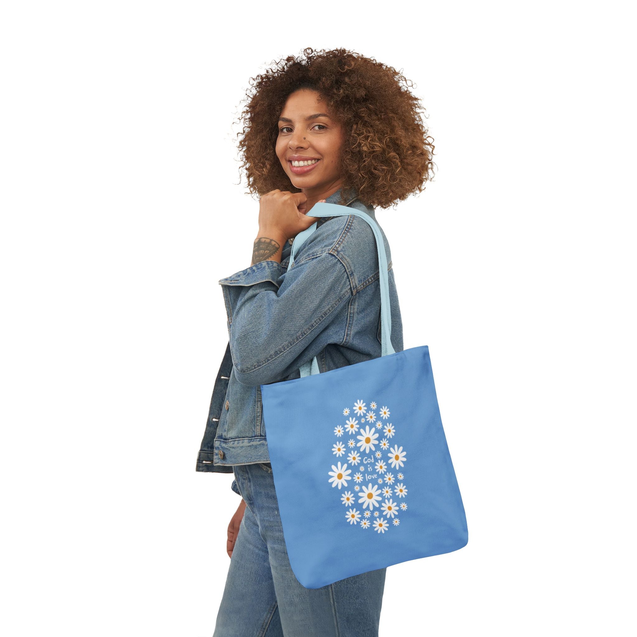 Woman holding a blue tote bag with a floral design on a white background