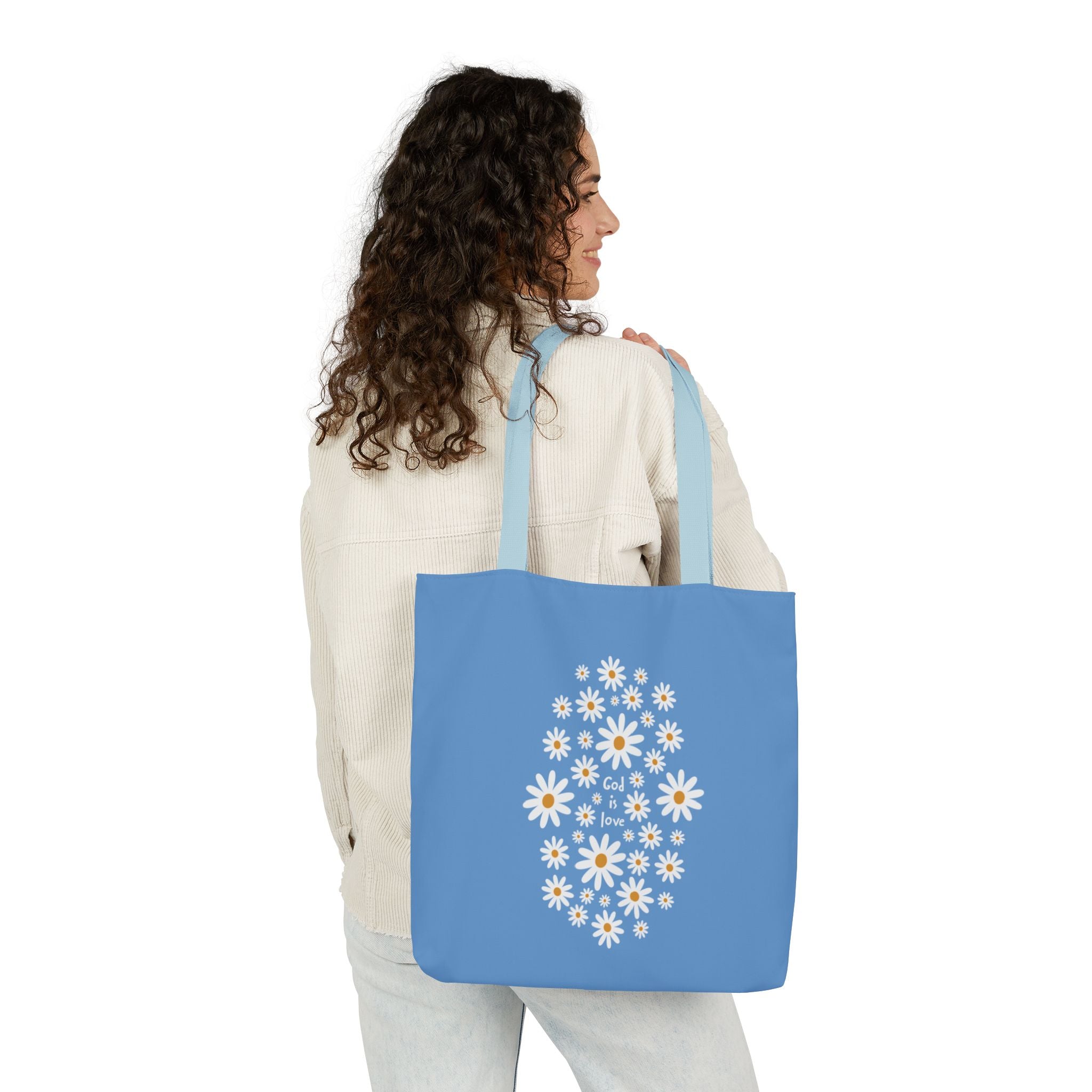 Woman holding a blue tote bag with floral design on a white background