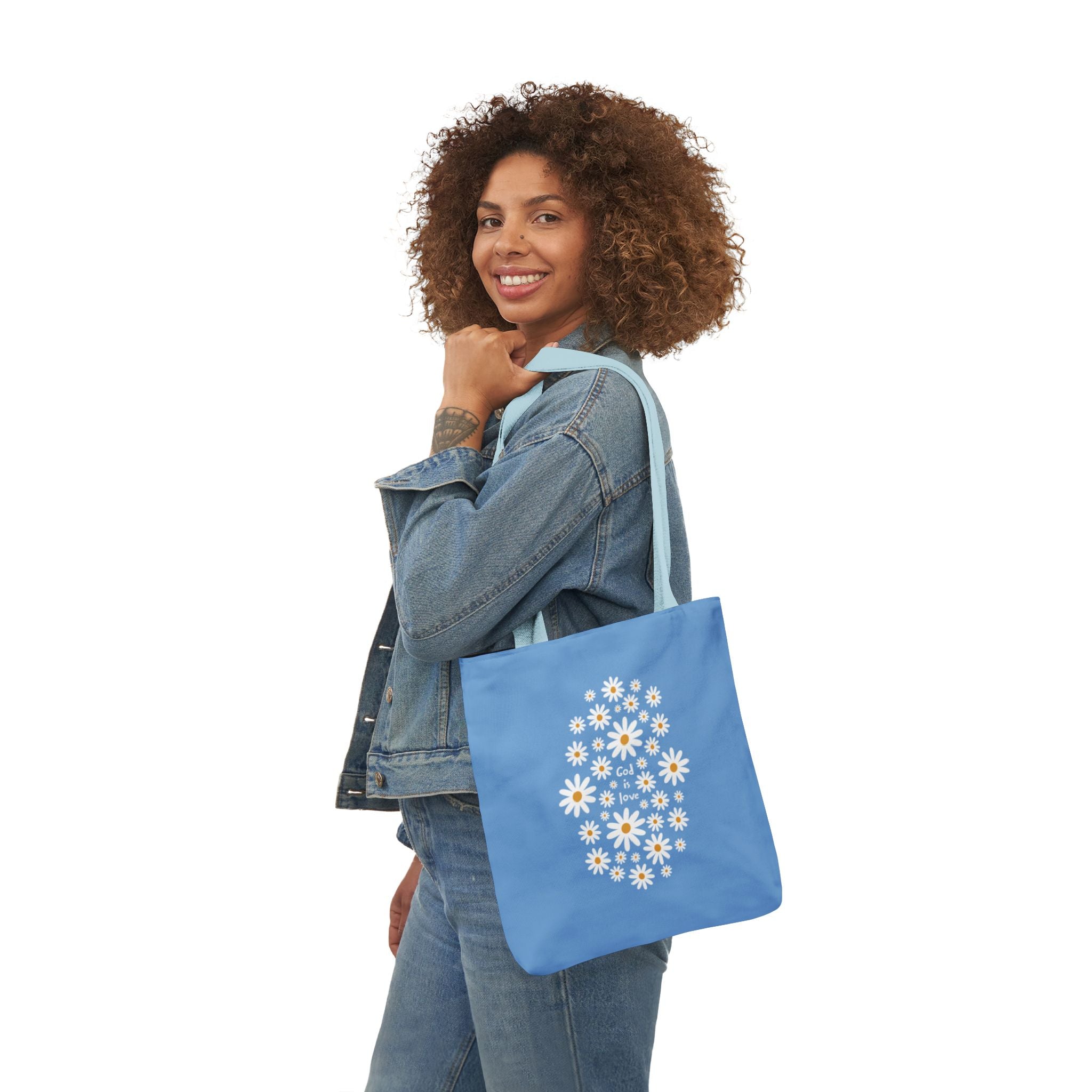 Woman holding a blue tote bag with floral design on a white background