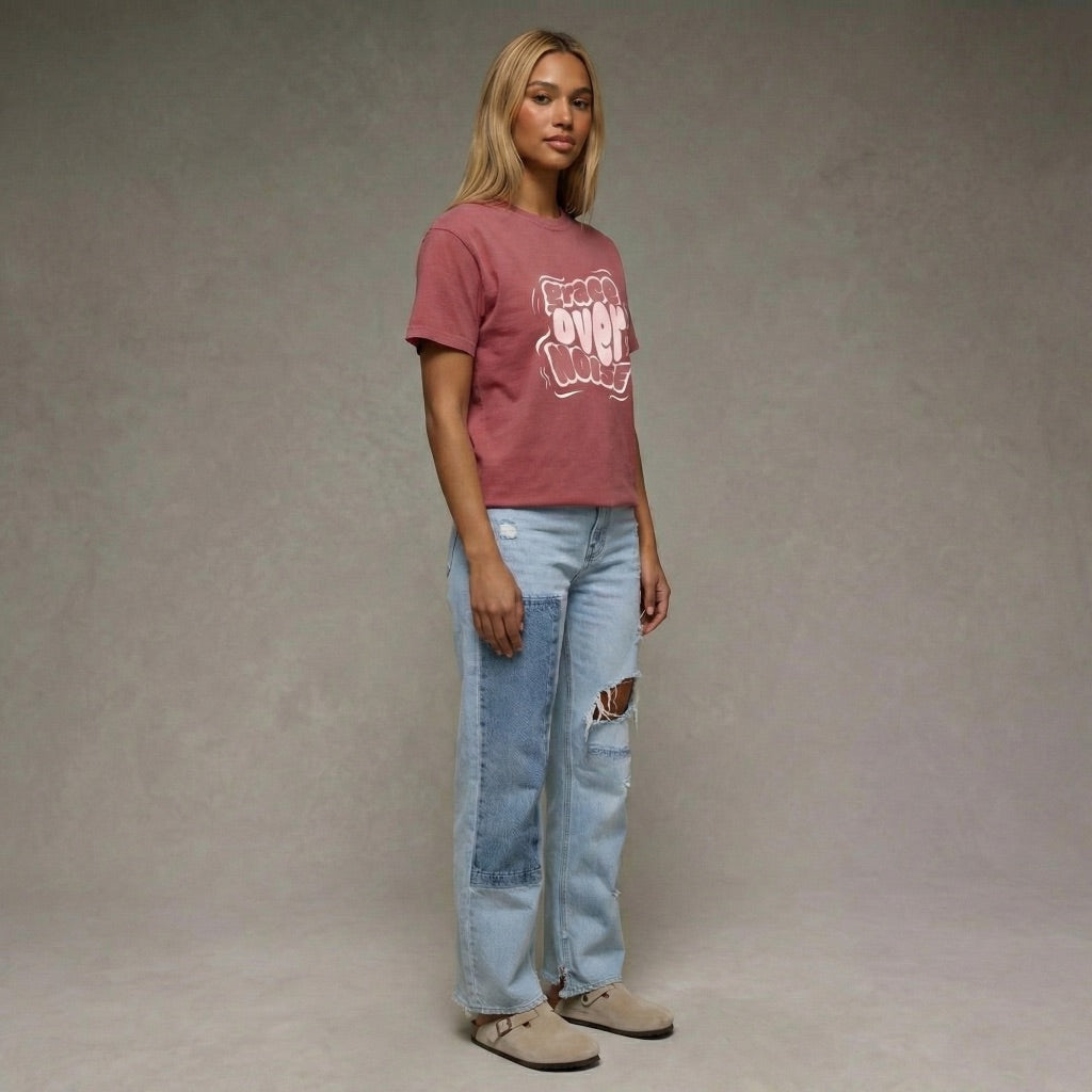 Woman wearing a maroon Grace Over Noise unisex t-shirt with white bubbly streetwear typography by Way Is Made 2